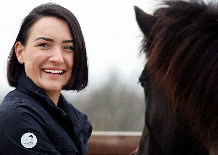 Eine Pferdephysiotherapeutin mit einem gescheckten Pony