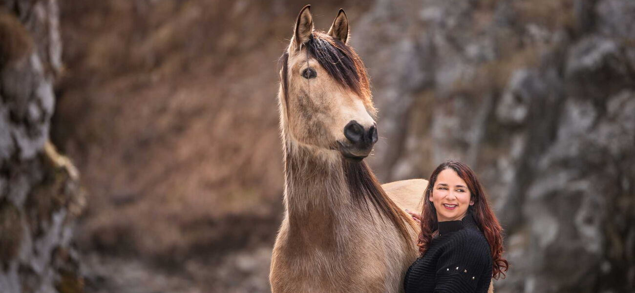 Pferdeverhaltenstrainerin posiert mit einem Pferd im kalten Winter